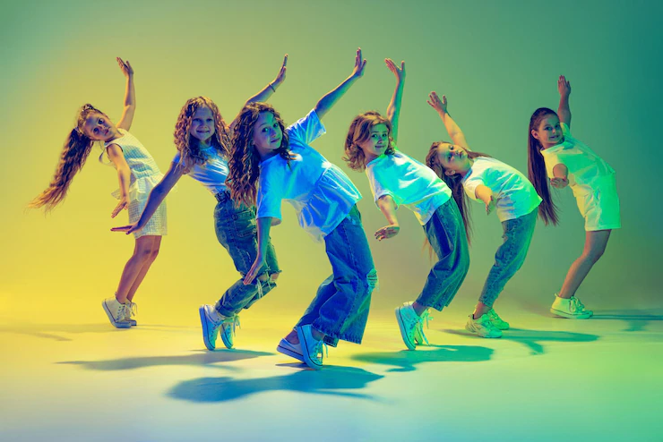 group-active-kids-cheerful-girls-dancing-isolated-green-background-neon-light_155003-46334